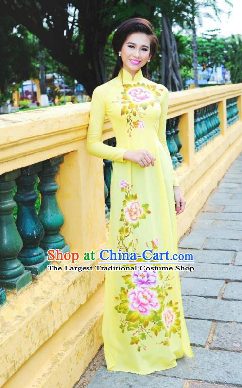 Vietnamese Ao Dai dress in yellow silk fabric. Hand-painted